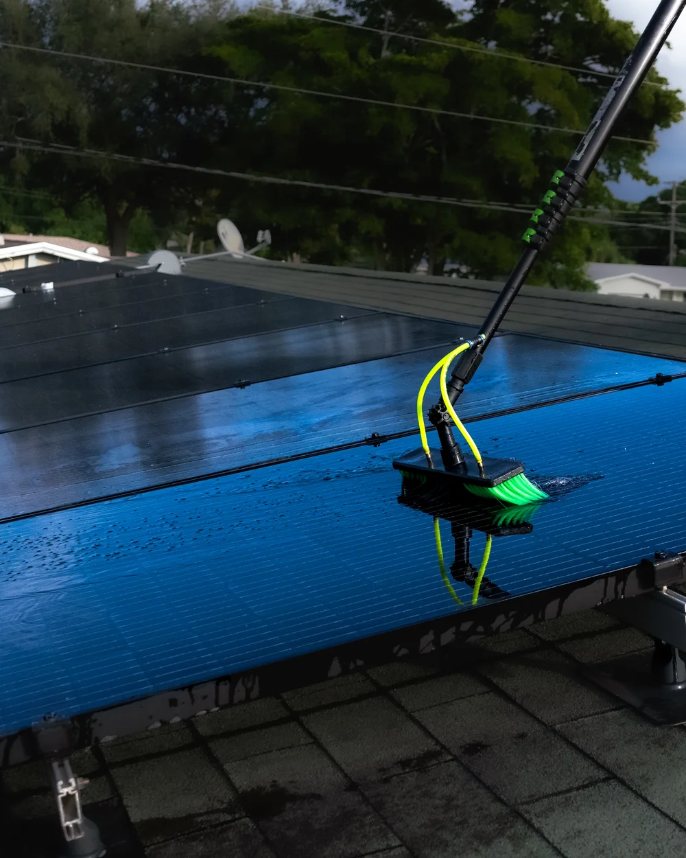 Solaris Solar Cleaning crew cleaning a rooftop solar array in Miami with a water-fed brush